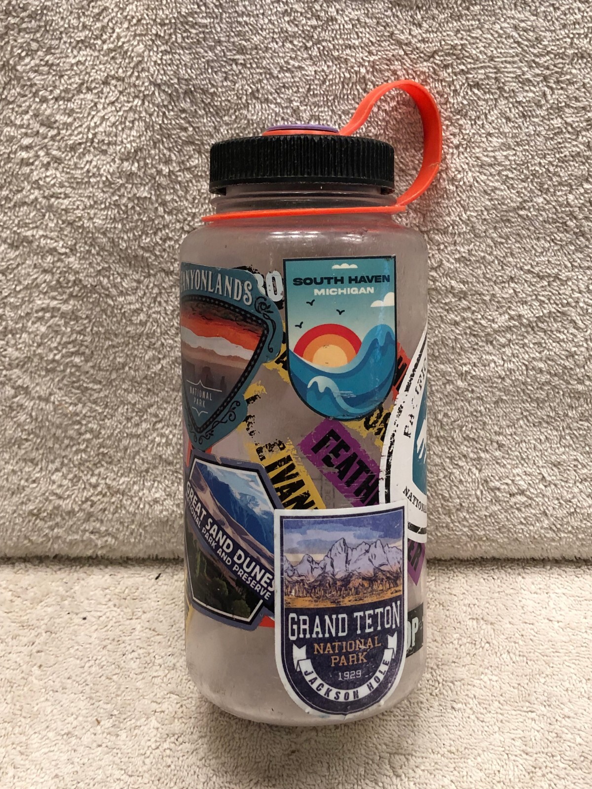 8 1/4 in tall empty bottle container by Nalgene with many National Parks Sticker