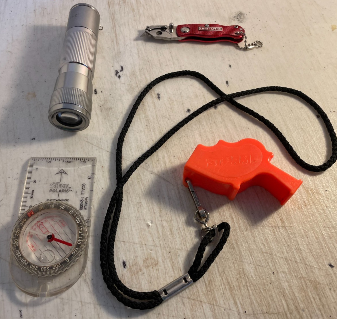 Survival kit junkyard: Storm whistle, Craftsmen box cutter, Silva compass